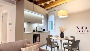 a kitchen and dining room with a table and chairs at MAcase Apartments in Ferrara