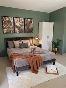 a bedroom with a large bed with green walls at La Residencia Homestay in Digos +1 photo