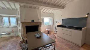 a living room with a table and a television at SuSuMare in Campiglia Marittima