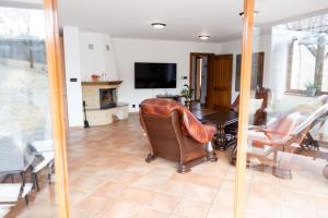 a living room with a chair and a table and a television at Club Apartments in Čeladná