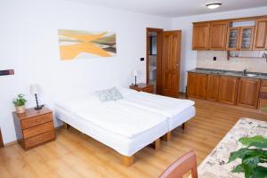a bedroom with a white bed and wooden cabinets at Club Apartments in Čeladná