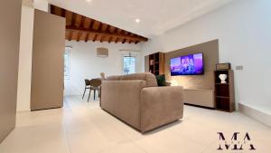 a living room with a couch and a tv on a wall at MAcase Apartments in Ferrara