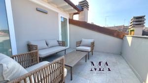 a balcony with two chairs and a bench on a building at MAcase Apartments in Ferrara