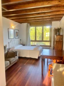 a bedroom with a bed and a couch and a table at Apartamentos Monterodiles in Liñero
