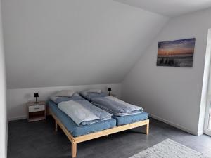 a bed with blue pillows on it in a room at Ferienwohnung Schöne Aussicht in Hinte