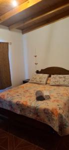 a bedroom with a bed with a cross on it at Cabaña Laynaturi in San Pedro de Atacama