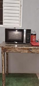 a microwave sitting on top of a wooden table at Recanto Morada do verde in Delfinópolis