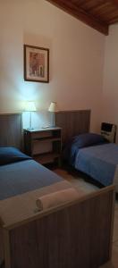 a bedroom with two beds and a desk with a lamp at Hermoso triplex concordia in Concordia