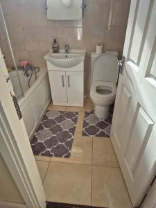 a bathroom with a toilet and a sink and a tub at 83 Clonmullion Athy county Kildare in Athy