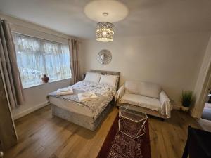 a bedroom with a bed and a chair and a chandelier at Lovely studio flat in Reading