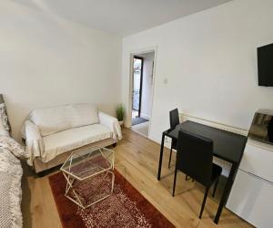 a living room with a couch and a table at Lovely studio flat in Reading