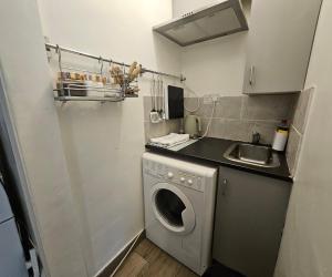 a small kitchen with a washing machine and a sink at Lovely studio flat in Reading +8 photos