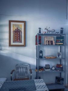 a room with a blue wall with shelves and a picture at Suite 3 in São Domingos
