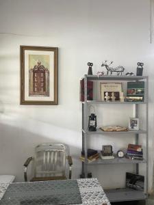 a room with a chair and a shelf with books at Suite 3 in São Domingos