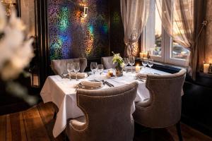 a table in a restaurant with a white table cloth at La Reine Hôtel & Restaurant in Spa