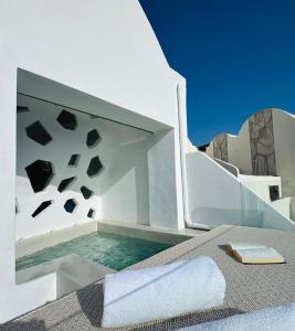 a plunge pool in a white building with a towel at Kaleidoscope Cave Houses in Oia