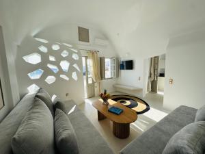 a living room with a couch and a table at Kaleidoscope Cave Houses in Oia