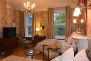 a bedroom with a bed and a living room at Manoir Sainte Genevieve in Quebec City
