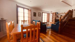 a dining room with a table and chairs and a living room at apartamentos lleguera 1 in Llanes +8 photos