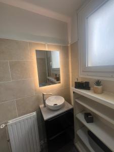 a bathroom with a sink and a mirror at Charming T2- apartment in Beauvais in Beauvais