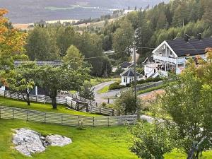 a village with a fence and a road and houses at Toppen House in Ringsaker