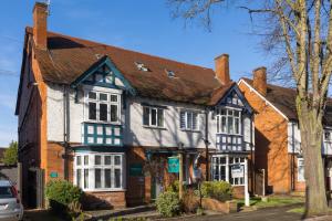 an old house with a black and white building at The Adelphi Aparthotel in Stratford-upon-Avon