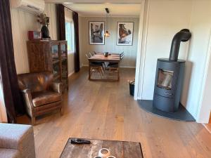 a living room with a wood stove and a table at Toppen House in Ringsaker