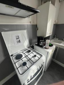 a white stove top oven in a kitchen at Charming T2- apartment in Beauvais in Beauvais