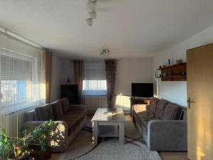 a living room with two couches and a table at Apartment AMRA in Tuzla