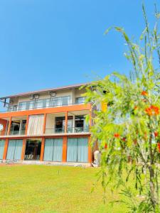 an orange building with a tree in front of it at Cinnamon Thiya in Dombagahawatta