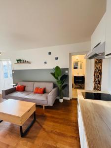 a living room with a couch and a table at Le Clemenceau - Appartements meublés in Gien