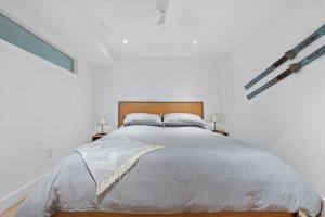 a bedroom with a large bed in a white room at Private Cedar Sauna Retreat - Kitchenette, King Bed, Spa Bath - Deep Cove in North Vancouver