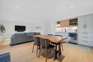 a kitchen and living room with a wooden table and chairs at Private Cedar Sauna Retreat - Kitchenette, King Bed, Spa Bath - Deep Cove in North Vancouver