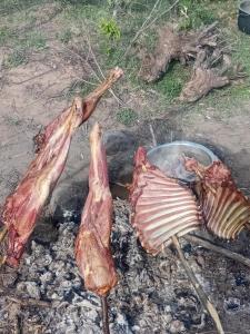 three pieces of meat cooking on a grill at Empiris homestay in Sekenani