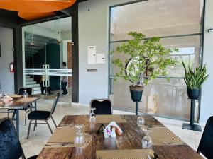 a restaurant with wooden tables and chairs and plants at Cinnamon Thiya in Dombagahawatta