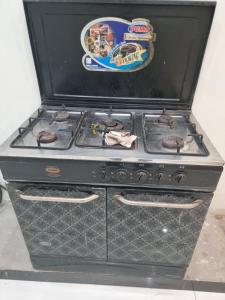 a black stove top oven sitting in a room at Elegance Abounds in Qila Malla Singh