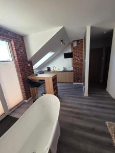 a room with a bath tub and a kitchen and a stair at Golden Heaven z wanną in Lębork