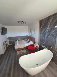 a bathroom with a bath tub and a bed at Golden Heaven z wanną in Lębork