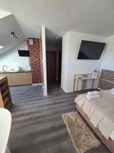 a bedroom with a large bed and a bathroom at Golden Heaven z wanną in Lębork