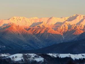 a view of a mountain range with snow covered mountains at Carpathia Magic -adults only in Peştera +56 photos