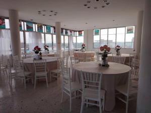 a room with tables and chairs with flowers on them at Hotel la fortuna in Tuxpan de Rodríguez Cano