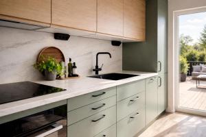 a kitchen with white cabinets and a sink and a patio at Skrylle Hideaway - cozy tiny house near Lund in Dalby