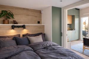 a bedroom with a large bed with a wooden headboard at Skrylle Hideaway - cozy tiny house near Lund in Dalby