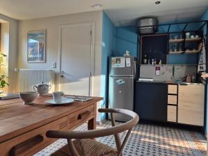 a kitchen with a wooden table and a refrigerator at Chambre de Amandine à Gerpinnes in Gerpinnes