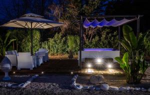 a table and chairs under an umbrella at night at Villa Kalia Luxury by HDSalento in Aradeo +32 photos