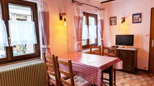 a dining room with a table and a television at Gites-Weyer La maison in Bergheim
