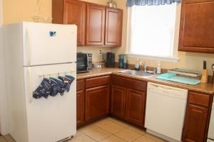 a kitchen with a white refrigerator and wooden cabinets at Charming 1 BR Apt 6 miles from Downtown! in Cincinnati