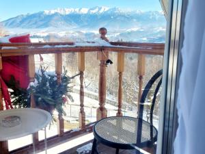 a balcony with a view of a snowy mountain at Carpathia Magic -adults only in Peştera