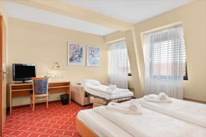 a hotel room with two beds and a desk at XZLLENZ light, Parken, 24h digitaler Check In und Zugang in Oberasbach