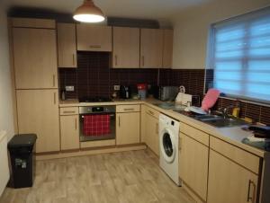 a kitchen with a sink and a washing machine at Double room Thornaby train station in Stockton-on-Tees